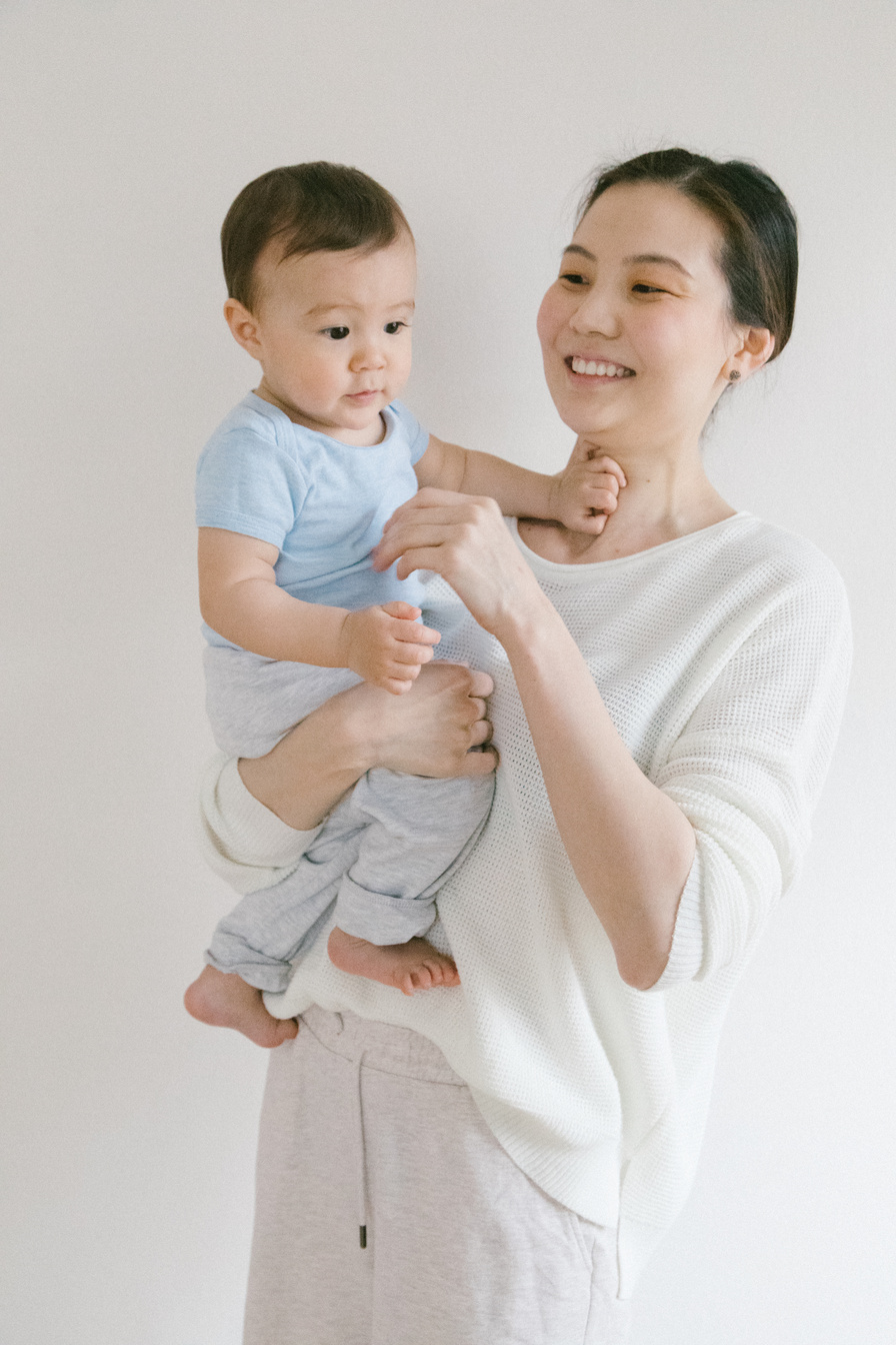 Woman in White Shirt Carrying Baby